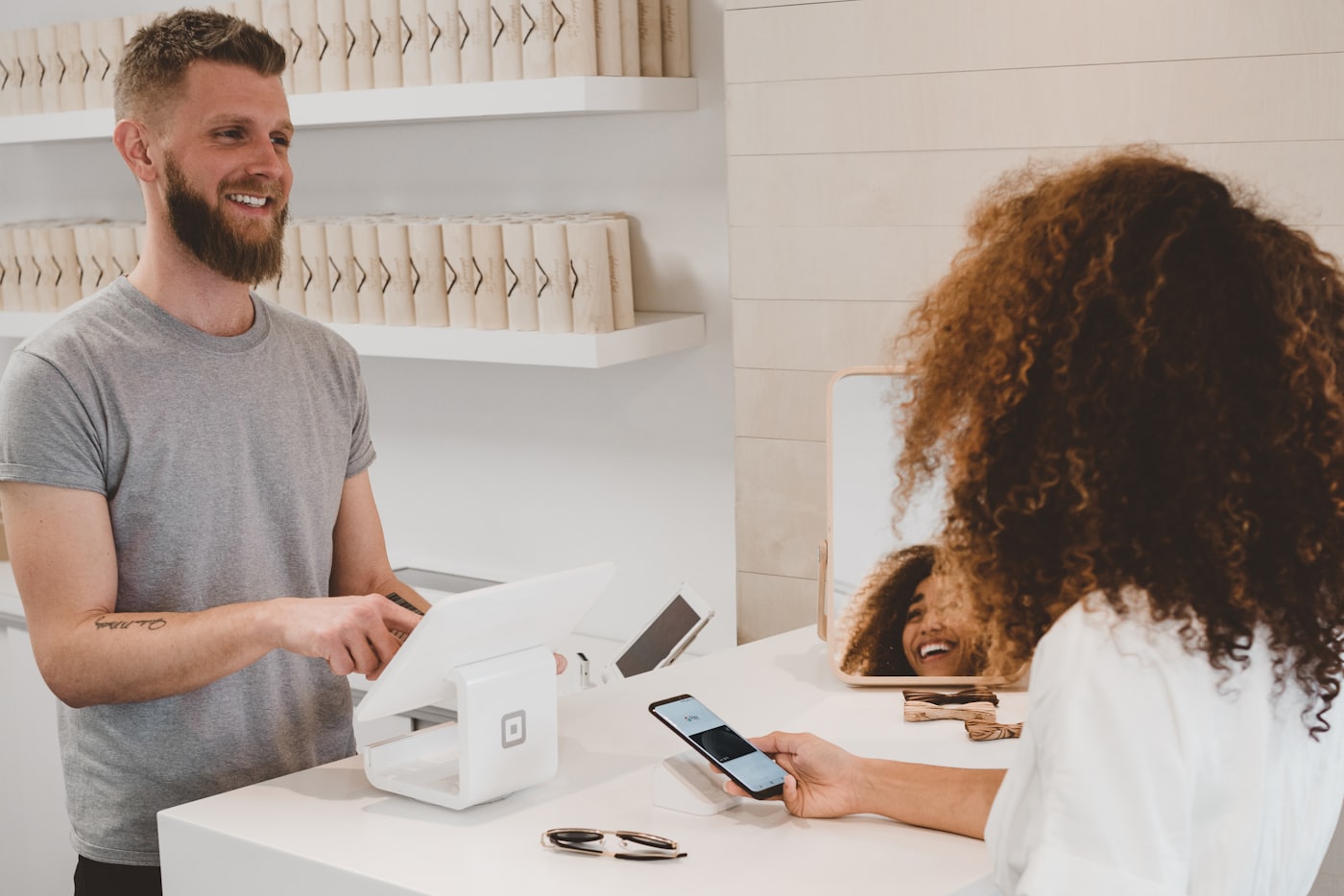 A customer paying by phone at a service counter